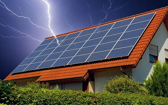 Blitz über einem Wohnhaus mit Solaranlage auf dem Dach