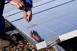 Monteur verschraubt ein Solarmodul mit der Unterkonstruktion