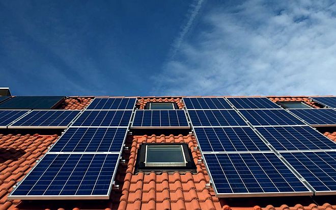 Ziegeldach mit mehreren Solarmodulfeldern und einem Dachfenster